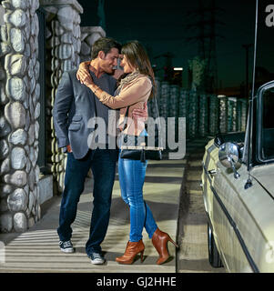 Giovane costeggiata da convertible auto classica di notte, Los Angeles, California, Stati Uniti d'America Foto Stock