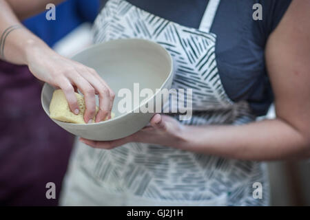 Ritagliato colpo di femmina levigatura potter ciotola finito in officina Foto Stock