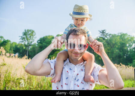 Padre che trasportano baby boy su spalle Foto Stock