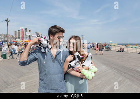 Giovane Azienda peluche mucche sorridenti, Coney island, Brooklyn, New York, Stati Uniti d'America Foto Stock