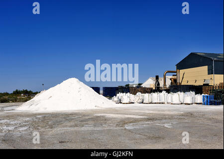 Sito azienda operativa di Aigues-Mortes salina nella Camargue dove fascicolatori di colline di stack di sale marino. Foto Stock