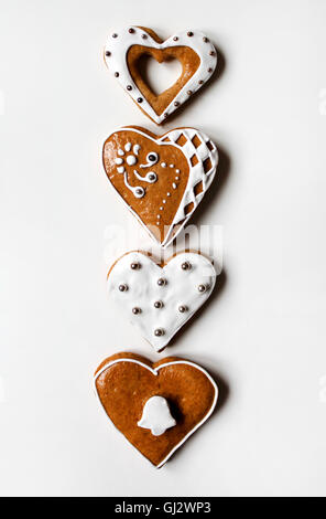 Fila di heart-shaped gingerbread su sfondo bianco Foto Stock