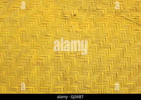 Giallo articoli di vimini per gli sfondi. Schema di tessitura artigianale realizzato da bambù. Foto Stock
