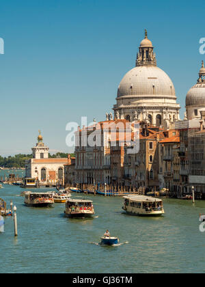 Barche sul Canal Grande con la cupola di Santa Maria della Salute in distanza. Venezia, Italia. Foto Stock
