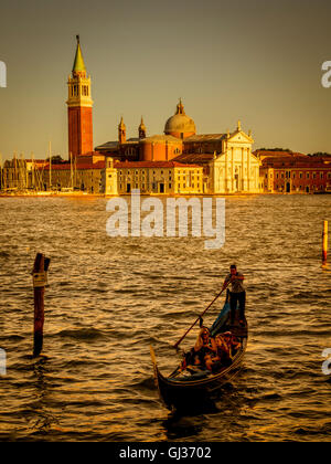 Single gondola sul Canale di San Marco, al tramonto con l'isola di San Giorgio Maggiore in background. Venezia, Italia. Foto Stock