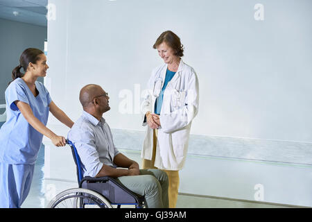 Medico di parlare all'uomo in sedia a rotelle Foto Stock