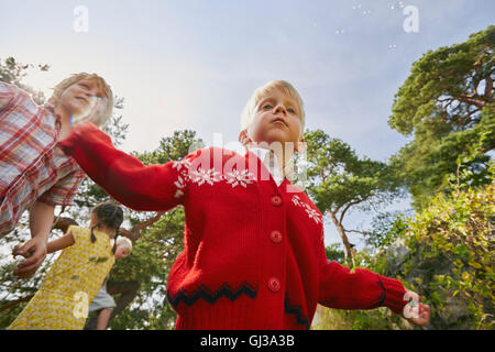 Piccolo gruppo di amici a giocare all'aperto e a basso angolo di visione Foto Stock