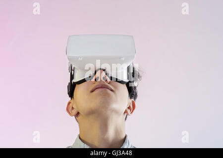 Giovane uomo che indossa la realtà virtuale auricolare cercando Foto Stock