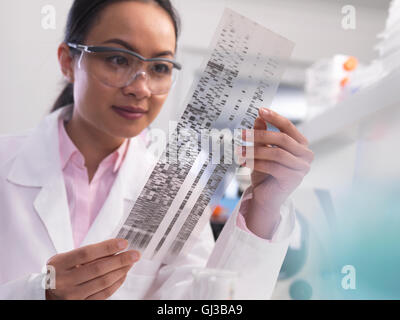 Scienziato visualizzazione di un profilo del DNA esperimento in un laboratorio Foto Stock