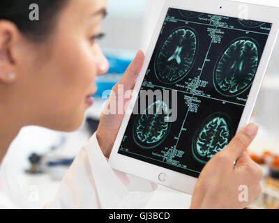 Medico CT di visualizzazione dei risultati della scansione del cervello sulla tavoletta digitale per le anomalie Foto Stock
