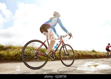 Ciclista equitazione sulla strada di campagna Foto Stock