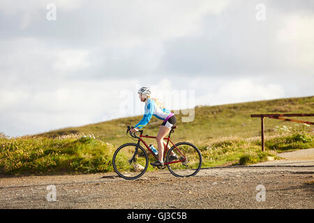 Ciclista equitazione sulla strada di ghiaia Foto Stock