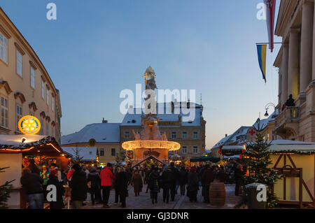 Baden: piazza principale con il municipio ( musicisti sul balcone ) e la Colonna della Santa Trinità al mercato di Natale, Austria, Niederö Foto Stock