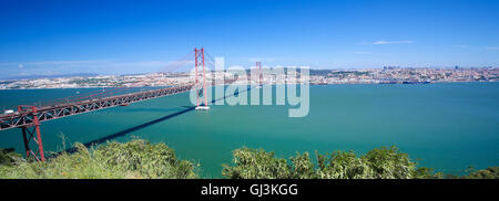 Il Ponte 25 de Abril attraverso il fiume Tago e vista sul centro di Lisbona, Portogallo Foto Stock