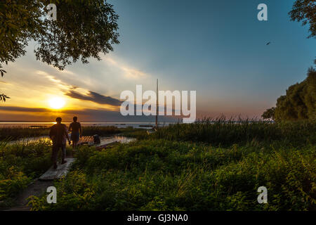 Due uomini sconosciuto soddisfare il sole al tramonto e per guardare le ultime pitture di estate Foto Stock