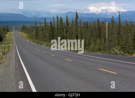 Il Edgerton Highway discese verso il rame River Valley con montagne innevate sullo sfondo. Foto Stock