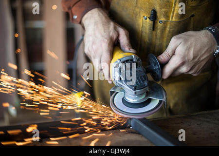 Arredamento personalizzato lavoratore grind saldatura sul telaio in acciaio. Foto Stock