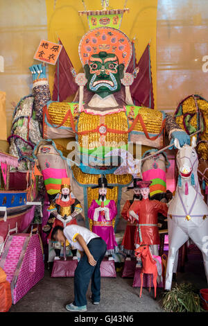 Kuala Lumpur, Malesia. 12 Ago, 2016. Un organo a stanghetta mantenendo la massa pulita dove un grande carta burattini di Re ade stand. Credito: Danny Chan/Alamy Live News. Foto Stock