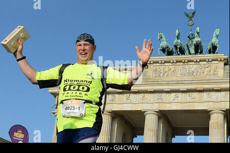 Berlino, Germania. 13 Ago, 2016. I partecipanti del quinto Mauerweglauf ("del muro di Berlino in esecuzione') in corrispondenza della Porta di Brandeburgo a Berlino, Germania, 13 agosto 2016. Circa 350 corridori singolari e relè 100 desidera gestire i 160 chilometri di pista. Foto: BRITTA PEDERSEN/dpa/Alamy Live News Foto Stock