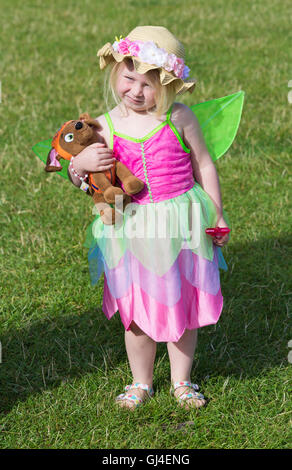 Burley, Hampshire, Regno Unito. 13 Ago, 2016. Giovane ragazza vestita come fata azienda cane giocattolo in una mano e la bacchetta in altri presso la New Forest Fairy Festival, Burley, Hampshire, Regno Unito nel mese di agosto del credito: Carolyn Jenkins/Alamy Live News Foto Stock