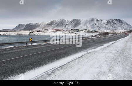 Congelati strada che conduce alla montagna innevata a Selfoss città in Islanda Foto Stock