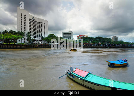 Kuching, Malaysia . Vista della città di Kuching waterfront e il fiume Sarawak con barche tradizionali Foto Stock