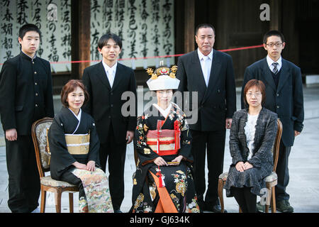 Dopo il tradizionale giapponese Shinto cerimonia di nozze le famiglie si riuniscono per un ritratto formale seduta immediato di un membro della famiglia Foto Stock