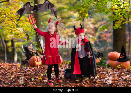 Due bambini divertenti indossando devil e vampire costume rosso con corna e trident trucco o trattamento di Halloween. Foto Stock