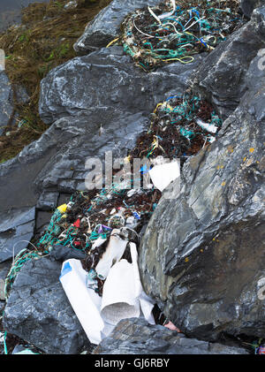 dh Jetsam terra rifiuti AMBIENTE RIFIUTI UK SCOZIA plastica flottsam lavato a riva su rocce di mare spiaggia figliata mare spazzatura Foto Stock