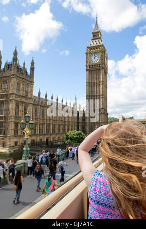 Giovane ragazza sul tour bus puntando verso il Big Ben e il parlamento di Westminster a Londra, Inghilterra, Regno Unito Foto Stock