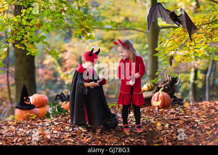 Due bambini divertenti indossando devil e vampire costume rosso con corna e trident trucco o trattamento di Halloween. Foto Stock