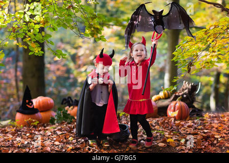 Due bambini divertenti indossando devil e vampire costume rosso con corna e trident trucco o trattamento di Halloween. Foto Stock