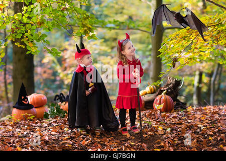 Due bambini divertenti indossando devil e vampire costume rosso con corna e trident trucco o trattamento di Halloween. Foto Stock