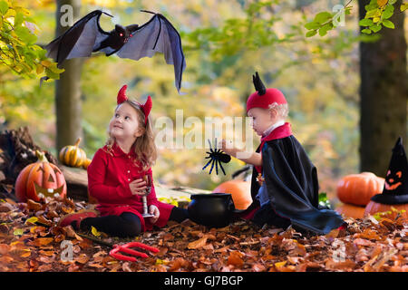 Due bambini divertenti indossando devil e vampire costume rosso con corna e trident trucco o trattamento di Halloween. Foto Stock