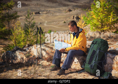 Backpacker mappa di lettura sulla foresta viaggio durante il riposo. Foto Stock