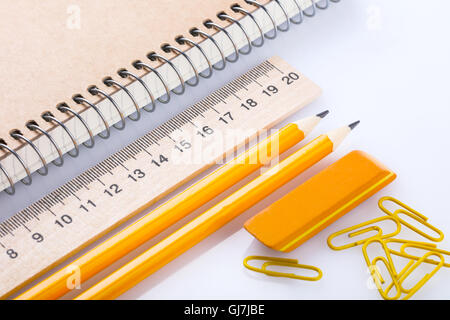 Notebook, eraser, righello matita e graffette su sfondo bianco Foto Stock