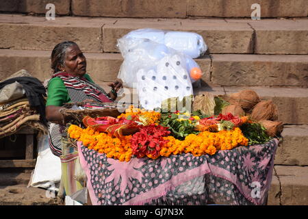 Donna indiana che vendono fiori per la cerimonia puja di Varanasi, Uttar Pradesh, India Foto Stock