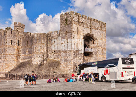 Turisti e tour in pullman a Caernarfon Castle, Gwynedd, Wales, Regno Unito Foto Stock