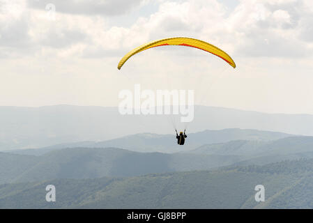 Il parapendio vola nel morbido cielo blu. Foto Stock