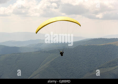 Il parapendio vola nel morbido cielo blu. Foto Stock