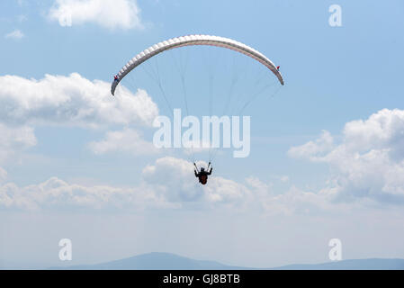 Il parapendio vola nel morbido cielo blu. Foto Stock