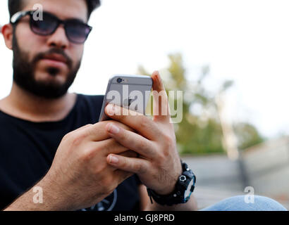 Teheran, Iran. 13 Ago, 2016. Un giovane uomo che utilizza un iPhone a Teheran, Iran, 13 agosto 2016. L'Iphone sono molto popolari in Iran, ma disponibile solo illegalmente a causa le sanzioni degli Stati Uniti. Il governo iraniano piani sull arresto del mercato illegale e importare i gadget tramite aziende selezionate. Tuttavia, Statunitense dei beni non sono ancora ammessi ad essere importati in Iran a causa delle sanzioni. Foto: FARSHID M. BINA/dpa/Alamy Live News Foto Stock