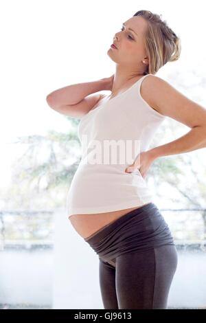 Modello rilasciato. Donna incinta strofinando il collo. Foto Stock