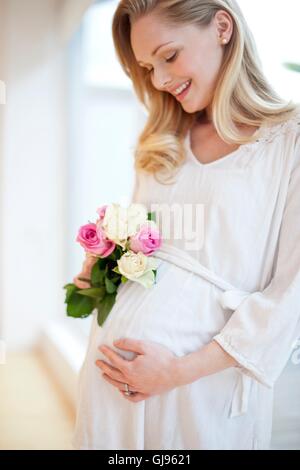 Modello rilasciato. Donna incinta holding posy di fiori. Foto Stock