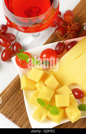 Piatto di formaggio fresco, un bicchiere di vino rosso e uva Foto Stock