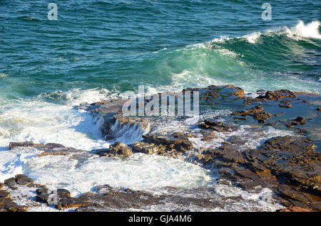 Onde spumeggianti su una roccia a mosaico platform alterate dall' oceano onde sulla New South Wales coast, Australia Foto Stock