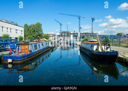 Narrowboats e gru riflessa nel campo di cotone marina Park, New Islington Ancoats, Manchester, Inghilterra, Regno Unito Foto Stock