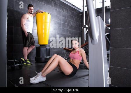 Una giovane coppia di prendere una pausa in palestra durante gli allenamenti. Foto Stock