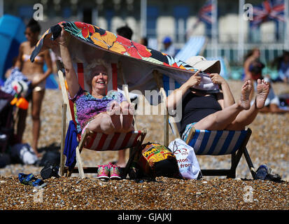 Sheila e Lilian Thompson (destra) Godetevi il clima mite sulla spiaggia di Brighton, East Sussex, come i britannici sono impostati per crogiolarsi in una tre-giorni di sunny scrivi come il mercurio sale ben al di sopra della media per questo periodo dell'anno. Foto Stock