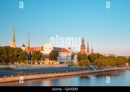 Vista panoramica al promenad di Daugava, a Riga, Lettonia. Vecchia Chiesa di torri e Castello medievale sullo sfondo. Il lungomare di nome Ab leggermente umido Foto Stock